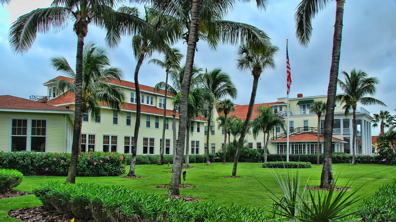 A Florida lodging property has palms, hedges, and a broad maintained lawn.